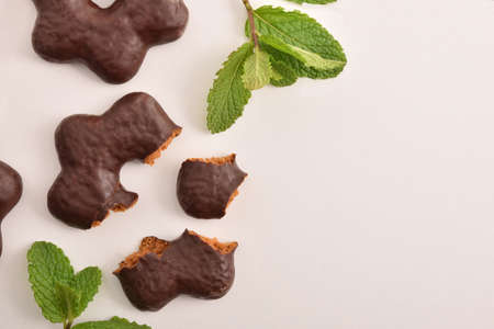 Cookies dipped in chocolates with star shape on white table with mint leaves. Top view. Horizontal composition.の写真素材