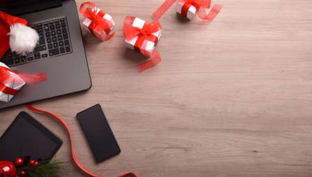 Internet christmas shopping background with laptop, card, shopping cart and gifts. Top view. Horizontal composition.の写真素材