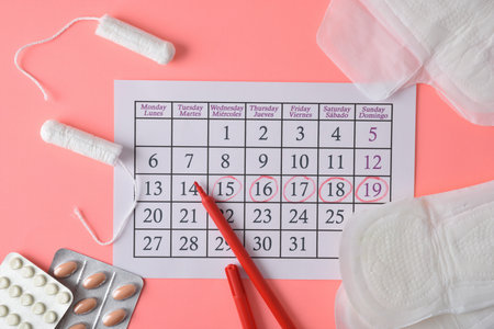 Menstrual calendar with marked critical days and various menstrual hygiene products and pills around...