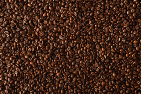 Background with heap of natural dry coffee beans close up. Top view. Horizontal composition.の写真素材