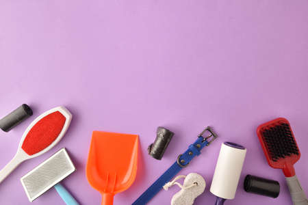 Accessories for cleaning dog droppings and hair on lilac background. Top view. Horizontal composition.の写真素材