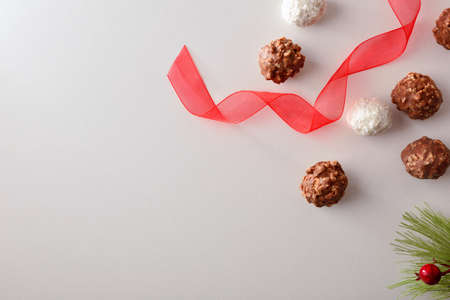Sweet balls for Christmas snack with chocolate and pieces of almond and coconut on white table. Top view.の写真素材