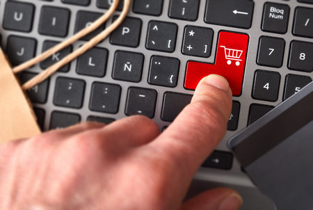 Finger pressing laptop key to order purchase order. Top view
