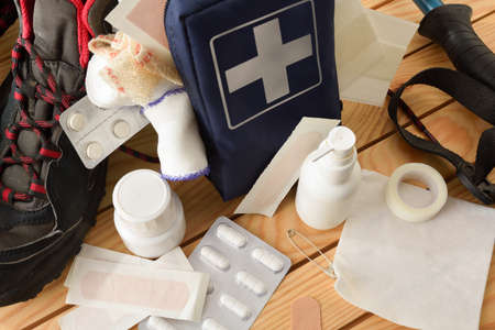 Basic portable first aid equipment for leisure nature sports events on wooden table and background of trees. Landscape composition. Elevated view.の写真素材