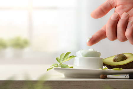 Hand testing natural avocado cream on duck with fruit with a window in the background. Landscape composition. Frontview.の写真素材