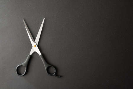 Basic conceptual hairdressing background with scissors on a black background and space to write. Topview. Landscape composition.の写真素材