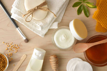Cosmetics with honey extracts with tools and toiletries on wooden table. Landscape composition. Top view.の写真素材
