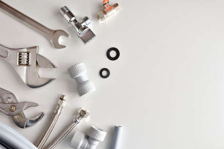 Plumbing background with tools and materials on white table. Top view. Landscape composition.の写真素材