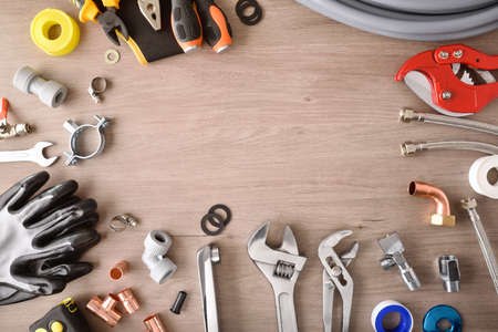 Plumbing materials and tools on wooden workbench top view frame background. Top view. Landscape composition.の写真素材