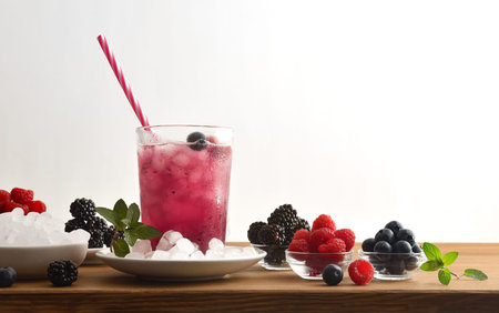 Beverage with berries with fruit and ice around with white isolated background. Frontview. Landscape...