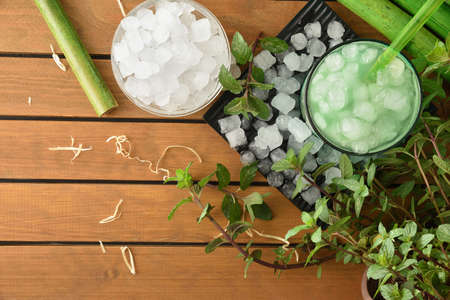 Natural iced mint on wooden table with crushed ice with leaves and plant around. Topview. Landscape composition.の写真素材