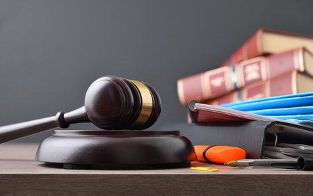 Concept of studying law career with books and class tools and gavel on wood table and isolated dark background. Frontview.の写真素材