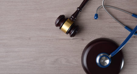 Concept background of justice in health and health in fair justice with gavel and stethoscope on wooden table. Top view.の写真素材