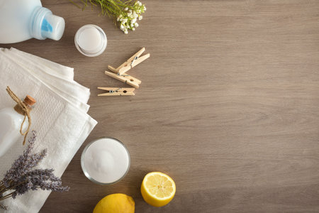 Clothes washing background with towels and products on wooden table. Top view. Landscape...