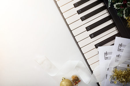 Christmas musical event concept background with piano on white table and Christmas decoration. Top...