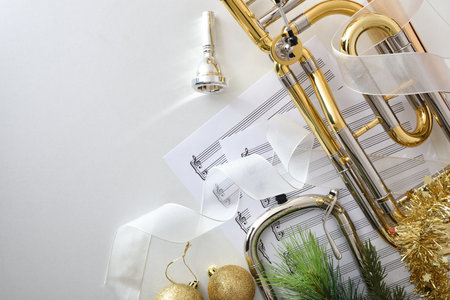 Trombone christmas music concert concept with christmas decoration sheet music and instrument on white table. Top view.の写真素材