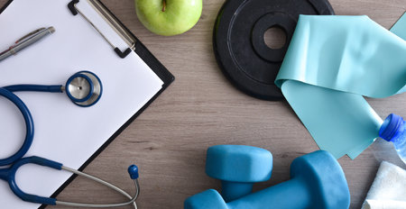 Sports medical technician table with notepad and stethoscope with sports equipment around. top view.の写真素材