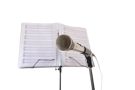 Microphone and music stand with folder with sheet music behind isolated on white background. Front view.の写真素材
