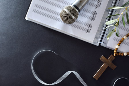 Choral music background for Palm Sunday with sheet music, microphone and olive branches with a...