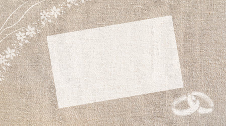 Wedding background with blank space drawn on white with rings and floral motifs around on brown cloth.の写真素材