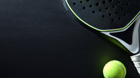 Detailed background of black and white paddle racket and ball on black background. top view.の写真素材