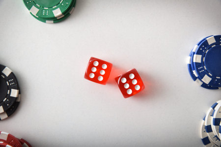 Casino dice game background with two red dice in the center and stack of different colored betting...