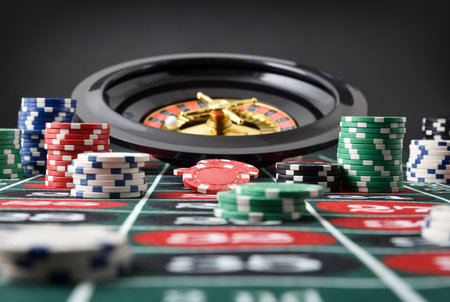 Detail of roulette game table with stacks of betting chips and roulette with isolated black background. Front view.の写真素材
