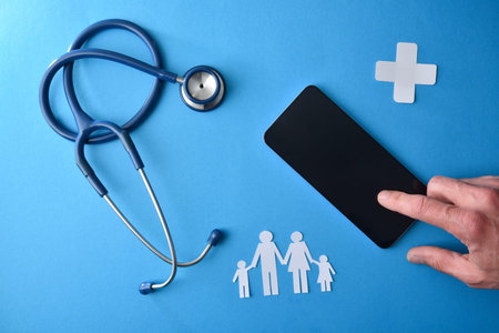 Concept of telephone care and family health insurance with hand using a smartphone on wooden base...