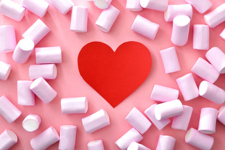 Conceptual background with red heart on pink background with sweets around. Top view.の写真素材