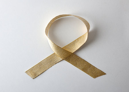 Shiny gold ribbon in corkscrew in upper right corner on white isolated background. Top view.の写真素材