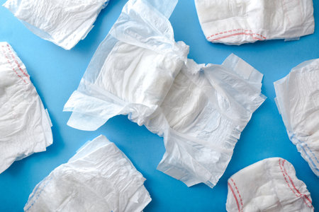 Background with new and clean diapers isolated on blue table. Top view.の写真素材