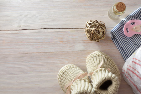 Background with baby clothes and accessories on wooden table. Top view.