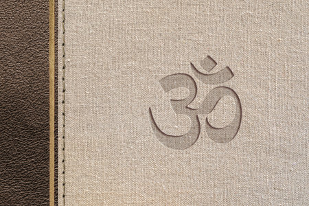 Brown hindu religious design with leather and fabric texture with hindu symbol engraved. Top view.