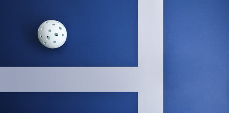 Sports background with white pickleball ball on a blue playing surface with white lines. Top view.の写真素材
