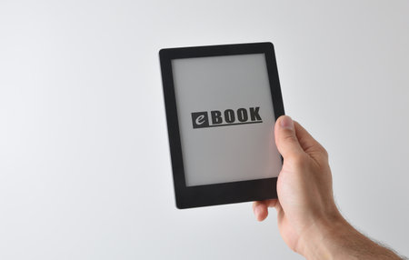 Detail of hand taking an ebook with written text isolated on white background. front viewの写真素材