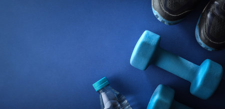 Indoor workout concept with sports equipment with dumbbells, sneakers on wooden platform. Top view.の写真素材