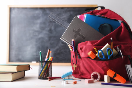 School education in a religious school with a red backpack full of tools and school supplies and a...