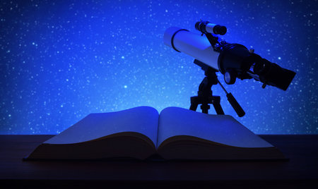 Concept of studying stars and constellations with open book on a wooden table at dusk and telescope focusing on a blue sky full of stars. Front view.の写真素材