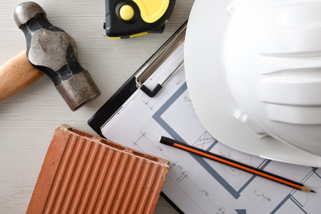 Conceptual background of construction materials and tools such as helmet, brick, hammer, meter stick...