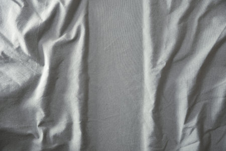 Detail of textured gray fabric wrinkled and ironed vertically in the center Top view.