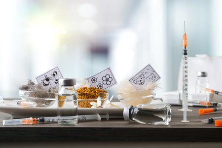 Vaccination concept for various allergens, with a dose, syringe, and allergen jars with an informational poster on a white table with the nursing room in the background. Front view.の写真素材