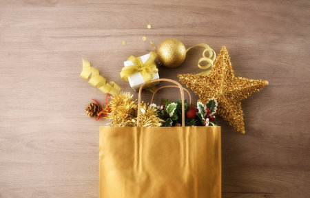 Christmas gift concept with a bag full of gifts and Christmas decorations on a wooden table. Top view.の写真素材