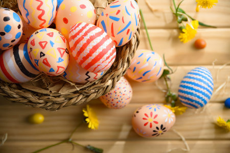 Close-up of pastel Easter eggs with vibrant hand-painted patterns in a wicker basket on a wooden...