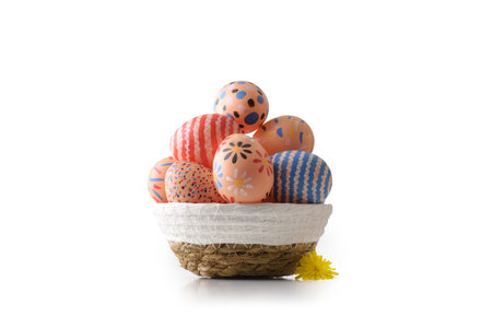 Woven basket filled with hand-painted Easter eggs featuring floral, striped, and dotted patterns on...