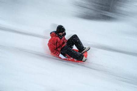 Kid sliding down in Madrid highway during Filomena storm in Madrid suburbsの写真素材