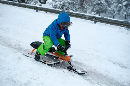 Kid sliding down in Madrid highway during Filomena storm in Madrid suburbsの写真素材