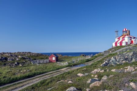 A red and white wooden lighthouse by the coast of Bonavista Newfoundland.の写真素材