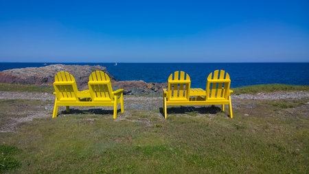 Chairs on the landscape looking at the ocean.