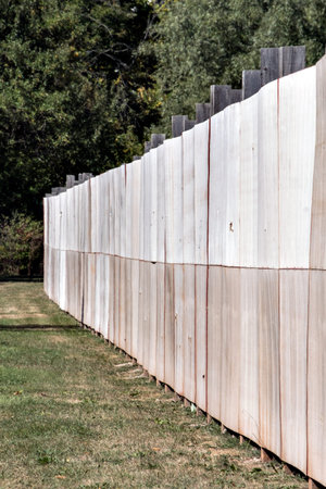 Wooden fence in a park with trees in the background in autumn