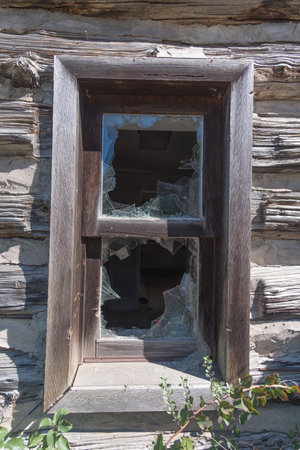 Window of an old abandoned wooden house with broken glass and broken glass.の写真素材